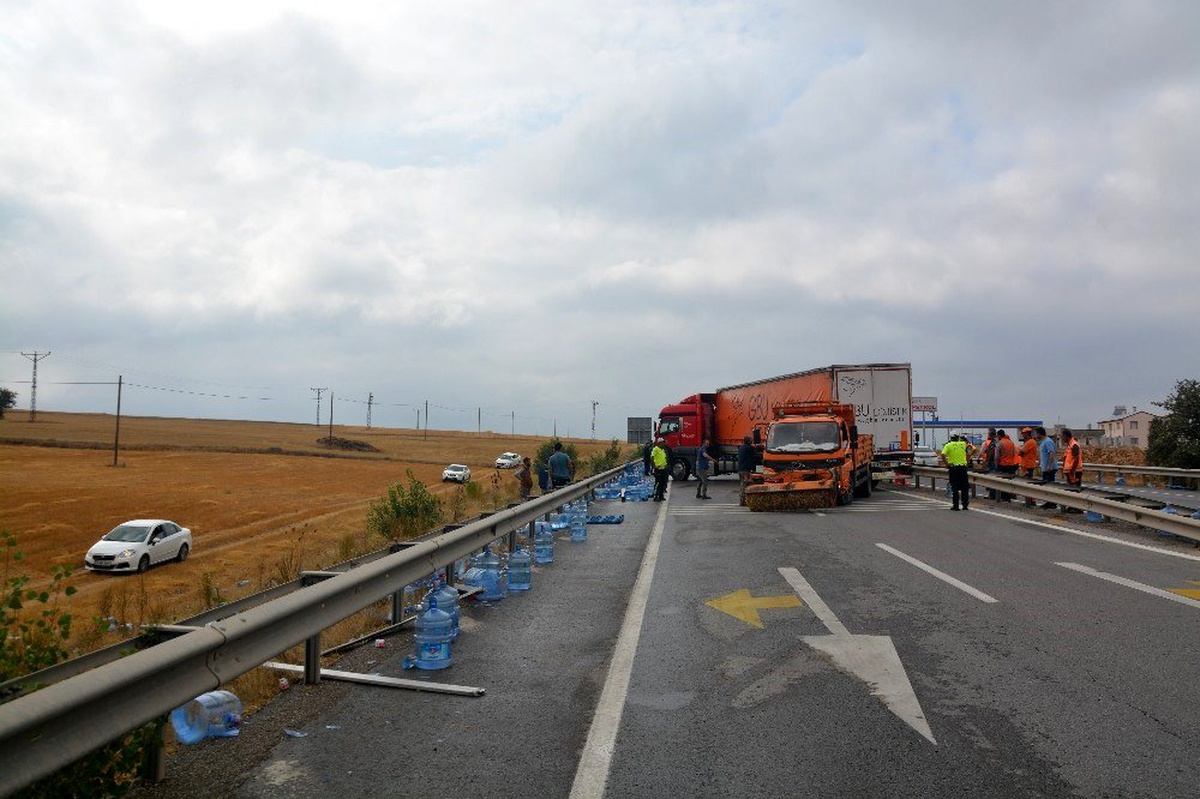 Tırdan yola dökülen su dolu damacanaları kendi araçlarına aldılar