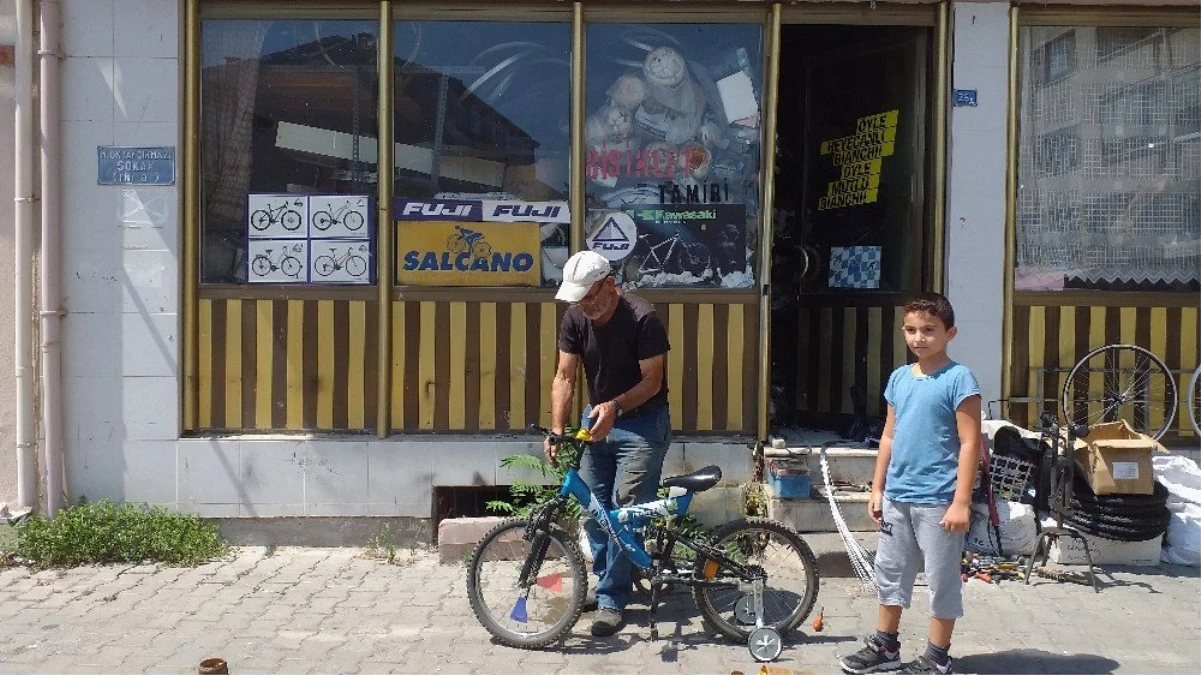 Aldığı emanet eşyalarla dükkanı dolduğu için bisiklet tamirini sokakta yapıyor