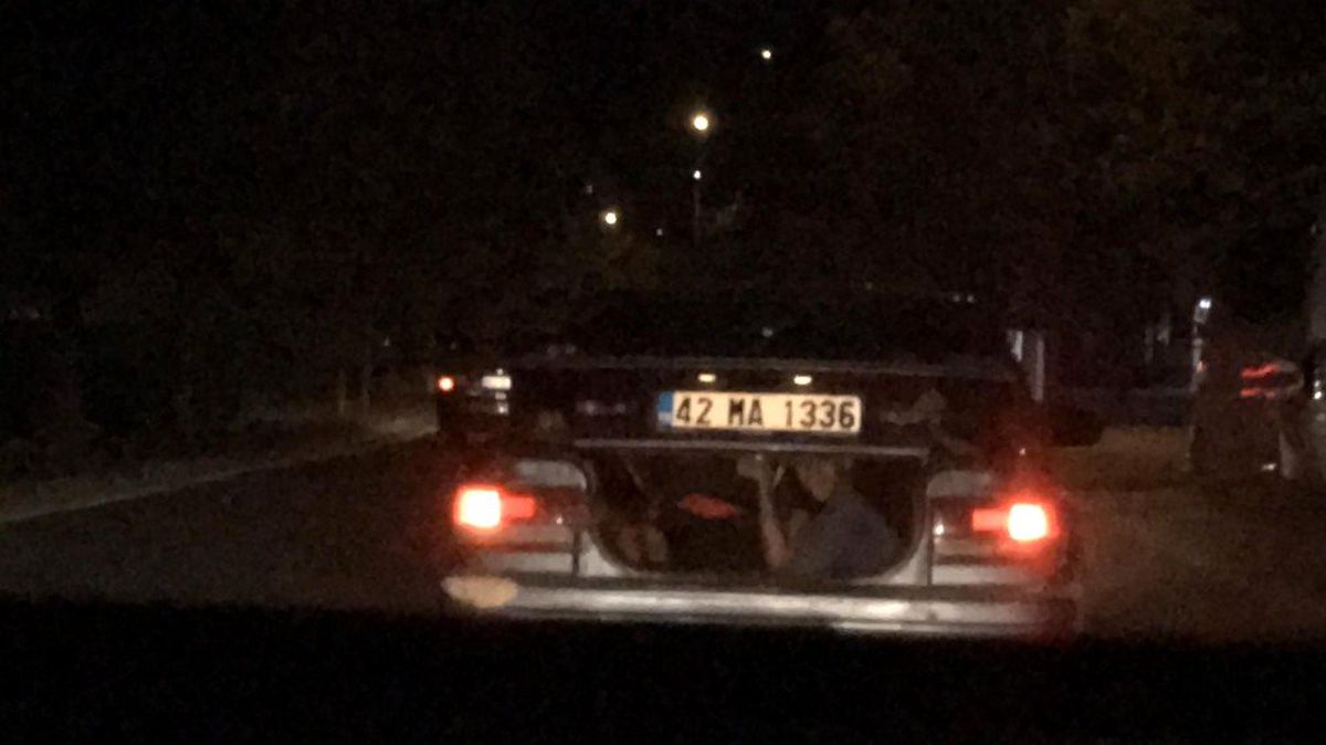 Otomobilin bagajından sürücüleri selamladılar