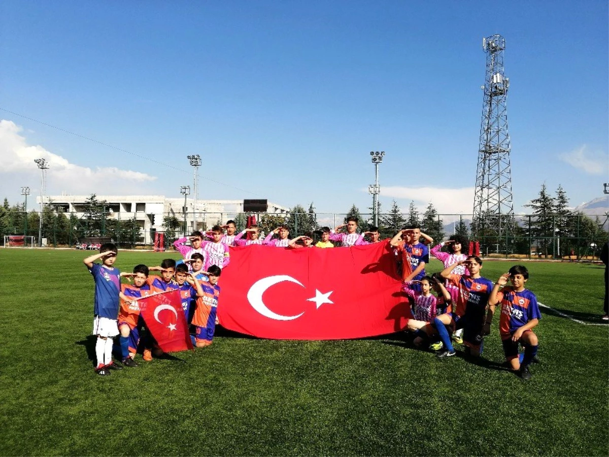 Yeşil sahada, miniklerden Türk Bayraklı asker selamı