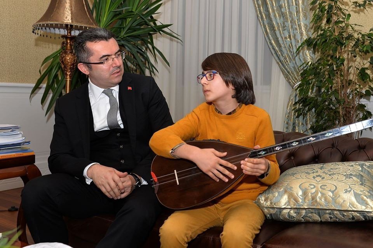 Vali Memiş bağlama çalan öğrenciye türkü söyleyerek eşlik etti