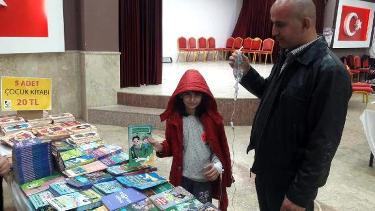 Kolunda serumla kitap fuarına geldi