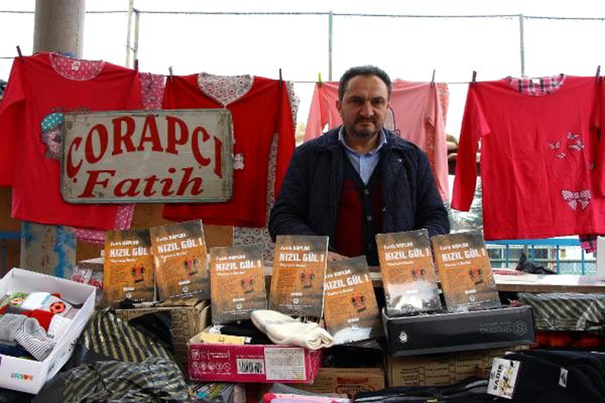 Yazdığı romanı, pazar tezgahında imzalıyor