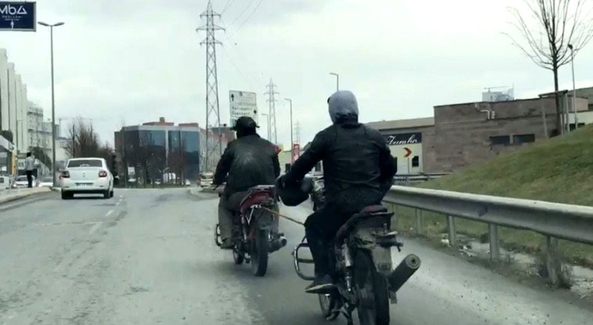 Kasksız motosikletli, yakıtı biten başka bir motosikleti iple çekti