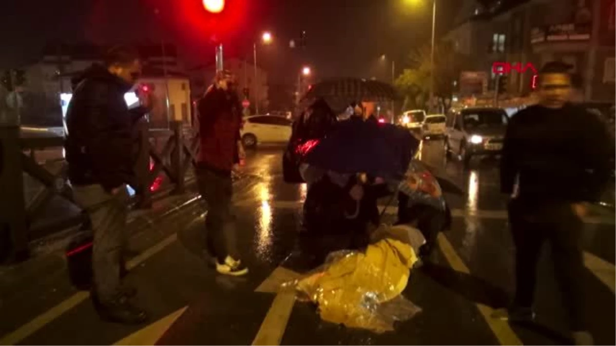 Motosikletten düşen kadını yağmurdan şemsiyeyle korudular