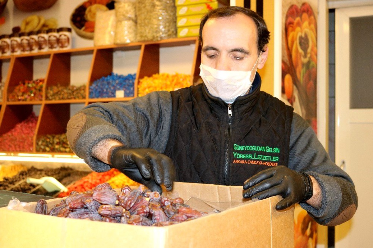 Kuru yemişçi, korona virüs tedbirleri kapsamında maske ve eldivenle çalışıyor