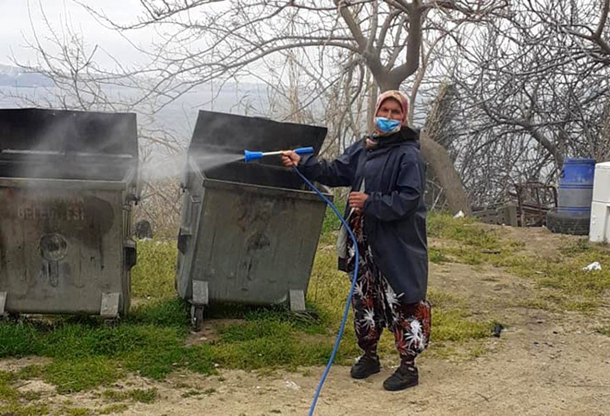 Kadın muhtar mahallesini dezenfekte ediyor