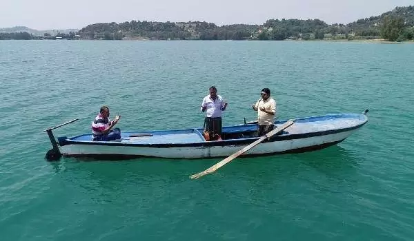 Su altında kalan mezarlığa sandalla giderek dua ettiler