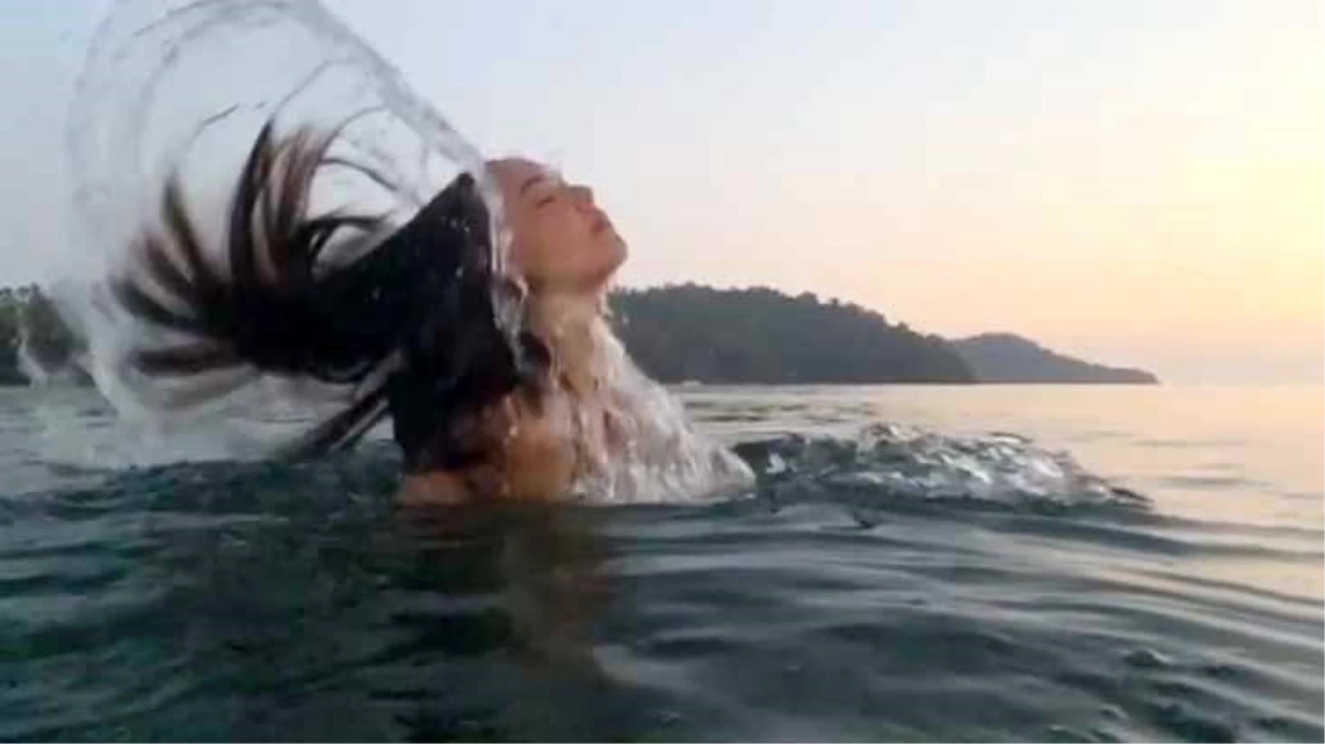 Tatiline hız kesmeden devam eden Azra Akın, saçlarını savurarak denizden çıktığı anları paylaştı
