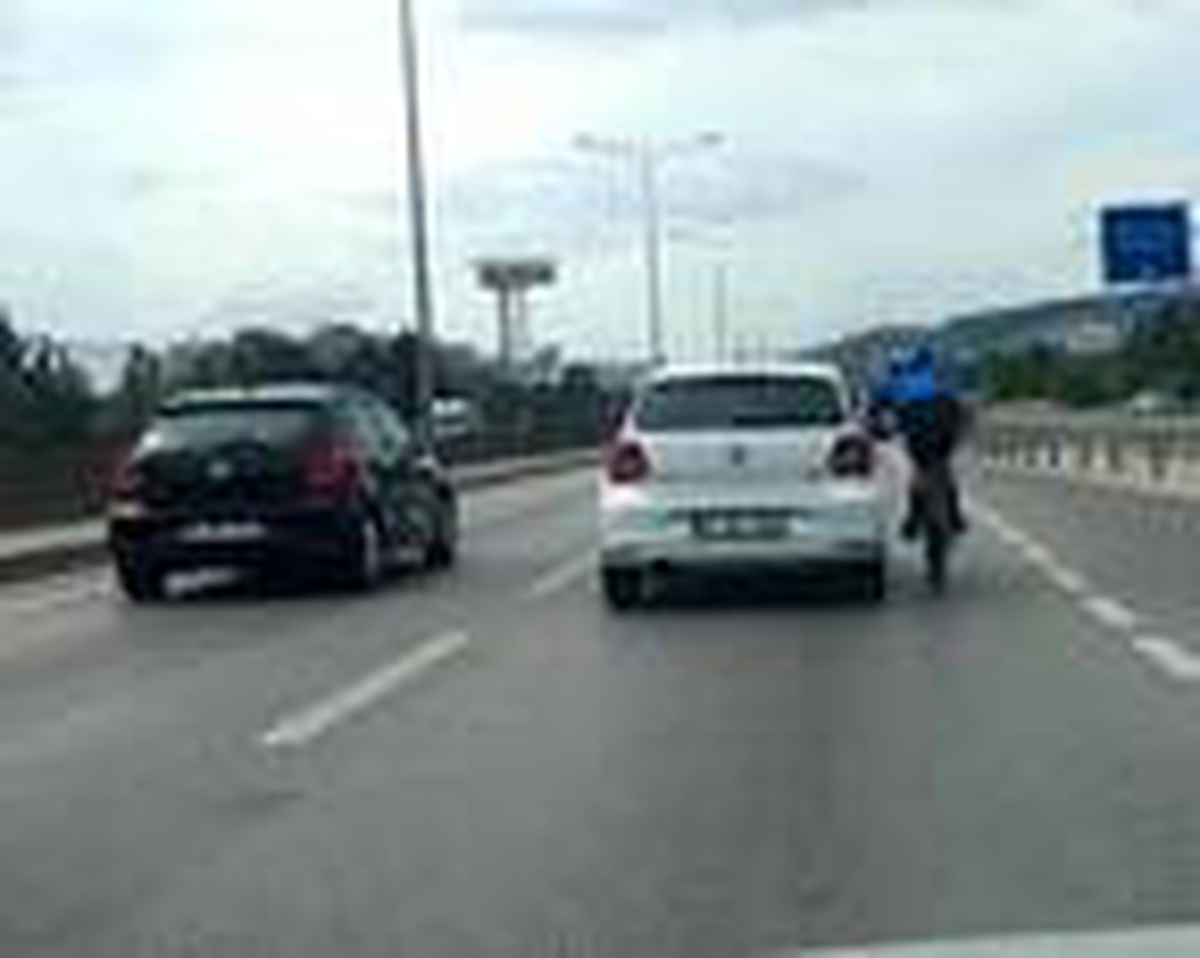 Bisiklet sürücüsü, otomobile tutunarak ilerledi