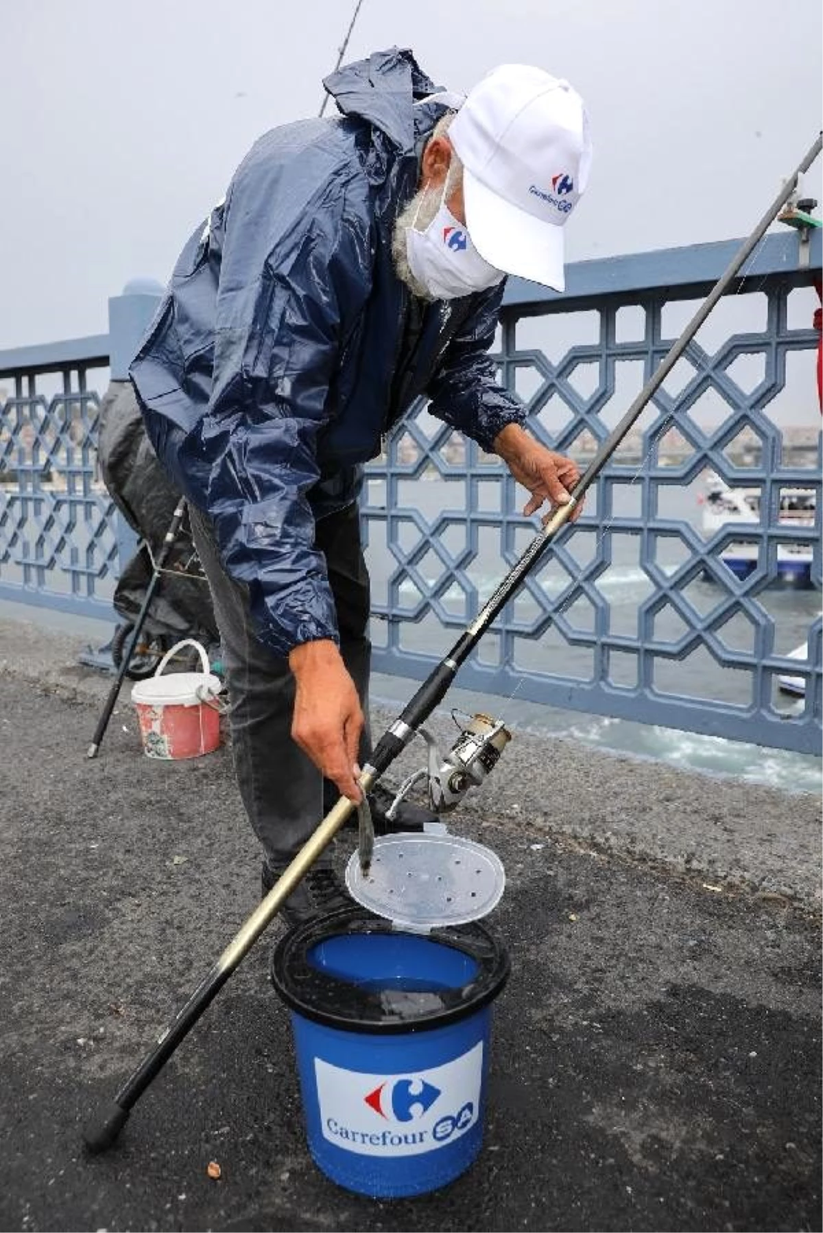 Galata Köprüsü\'ndeki balıkçılara yağmurluk, kova ve maske dağıtıldı