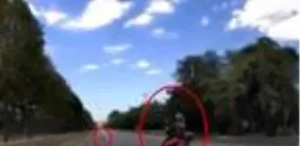 Motosikletlinin seyir halindeyken yerdeki çöpü ayağıyla alma anı kamerada