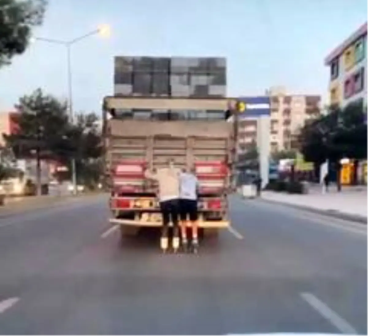 Patenli gençler hayatlarını tehlikeye atıp kamyonun arkasında ilerlediler