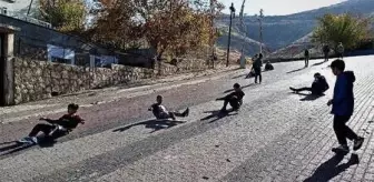 Henüz karın yağmadığı Gercüş'te çocuklar, yokuş aşağı tahta parçalarıyla kayıyor