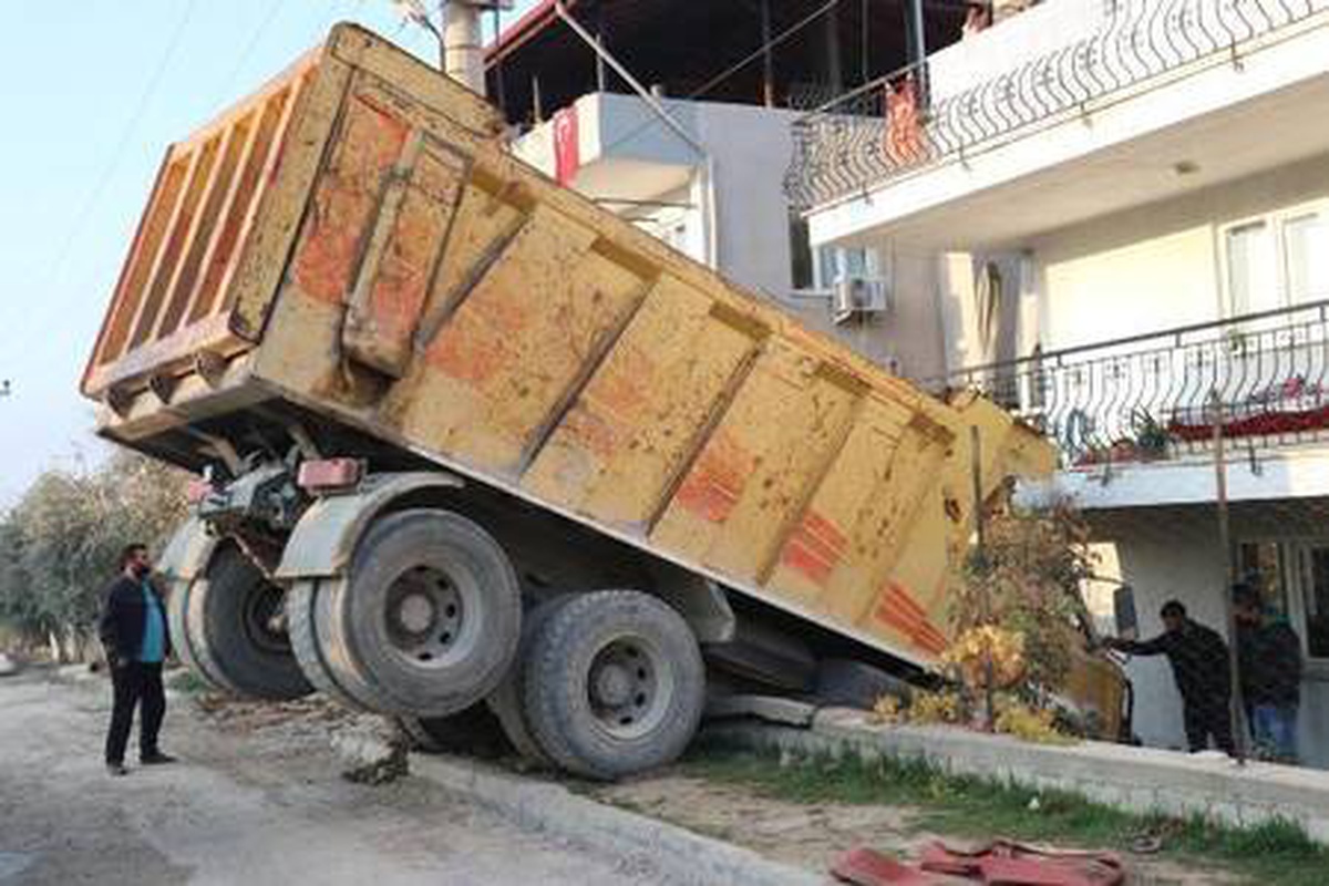Freni boşalan hafriyat kamyonu apartmanın bahçe duvarında asılı kaldı
