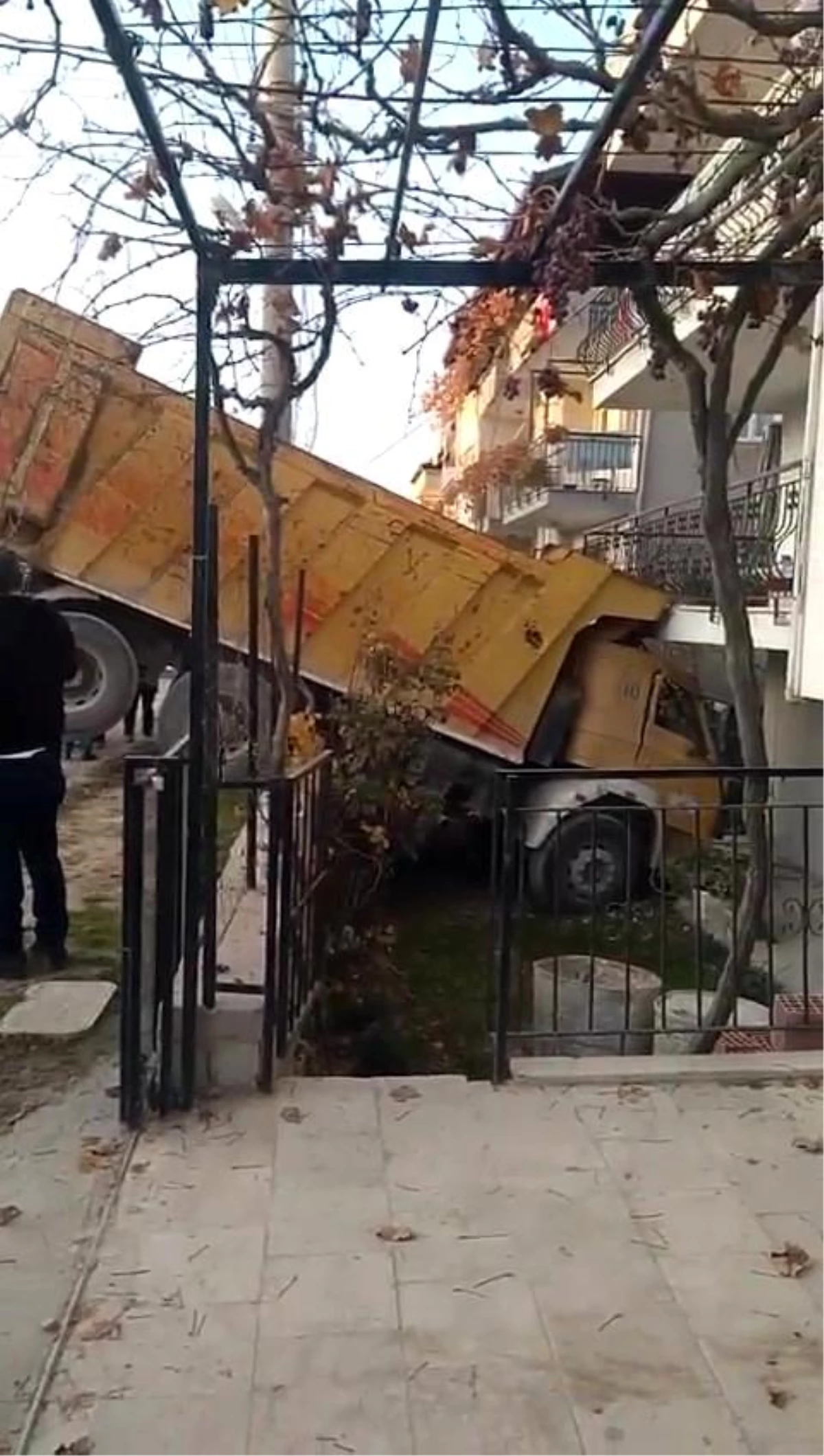 Freni boşalan hafriyat kamyonu ev ve yol arasında asılı kaldı