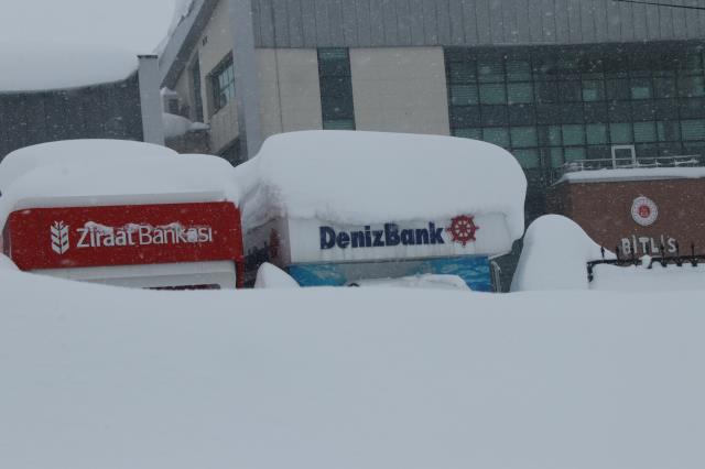 ATM'lerden paralarını boyu iki buçuk metreyi aşan karın üstüne oturarak çekiyorlar