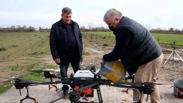 Antalya'da bir üretici üzerinde 10 litrelik depo bulunan droneyi zirai ilaçlamada kullanıyor