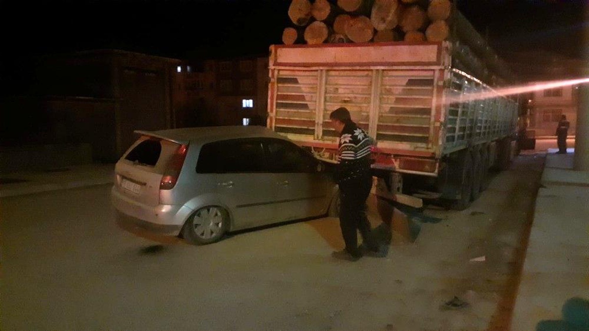 Otomobil park halindeki tırın altına girdi