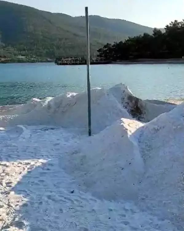 MUĞLA Bodrum'da plaja dökülen kuvars tozu, iş makineleriyle kaldırılmaya başlandı