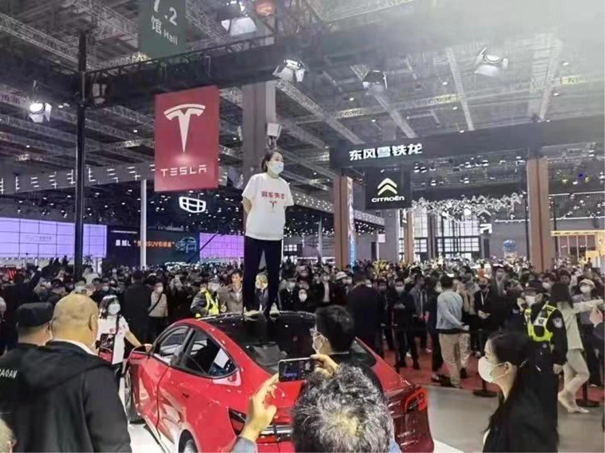 Çinli kadından Tesla protestosu: Fuarda aracın üzerine çıkıp bağırdı
