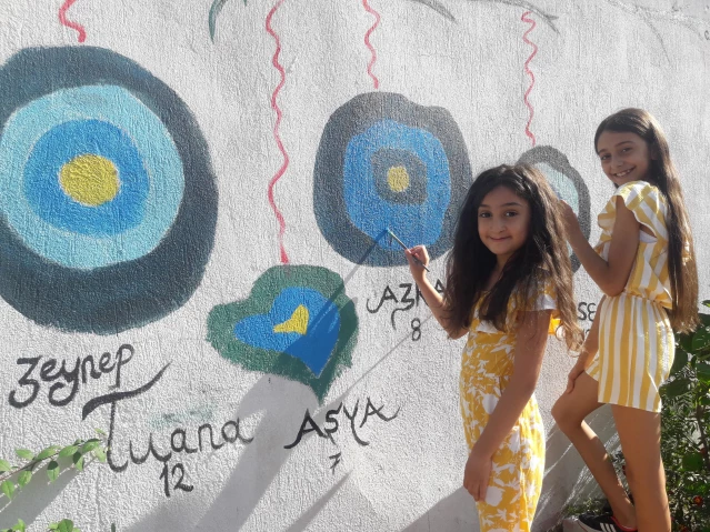 Yerel Hatay'da yaşadıkları mekanı güzelleştirmek isteyen aile, duvarlara rengarenk resimler çizdi
