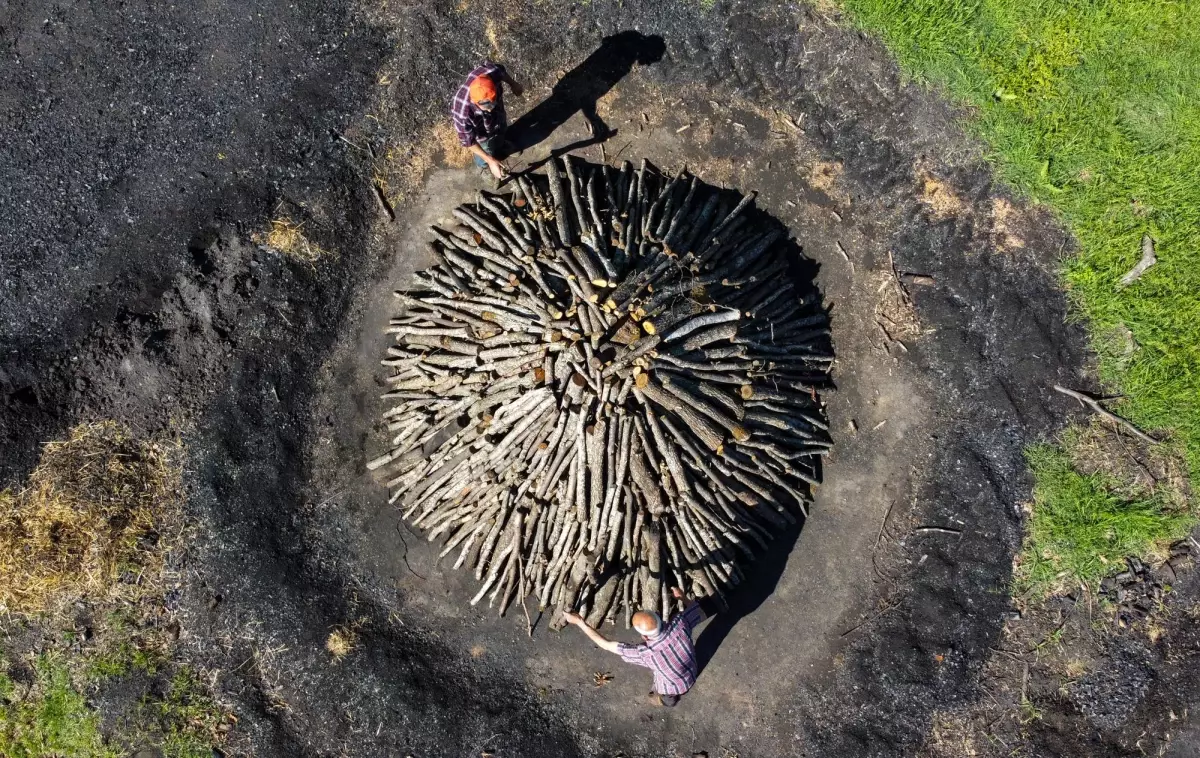 Toprak ve yaprakla üzerini kapattıkları meşe odunlarını mangal kömürüne dönüştürüyorlar