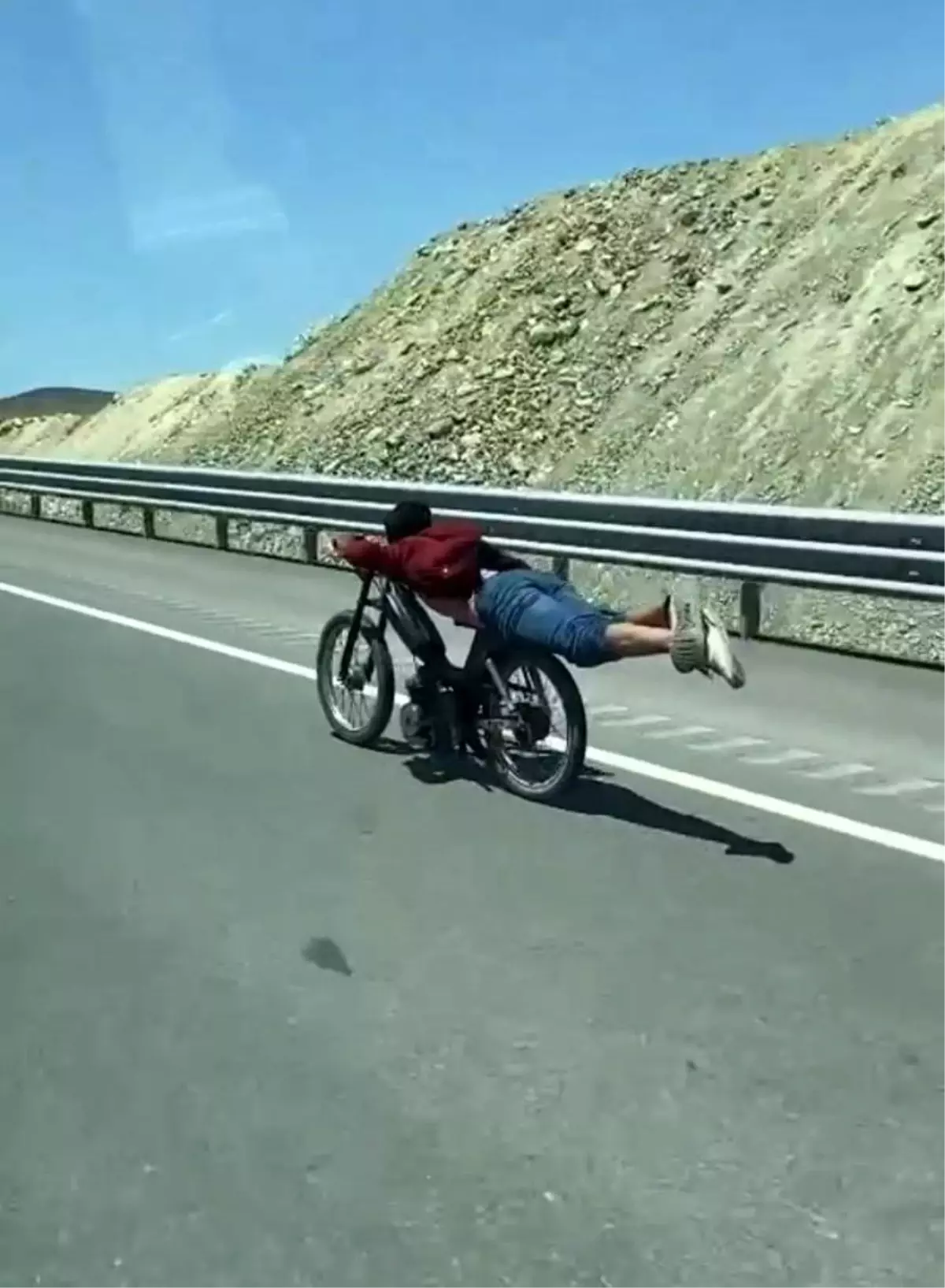 Motosikletin üstüne yatan sürücünün tehlikeli yolculuğu kamerada