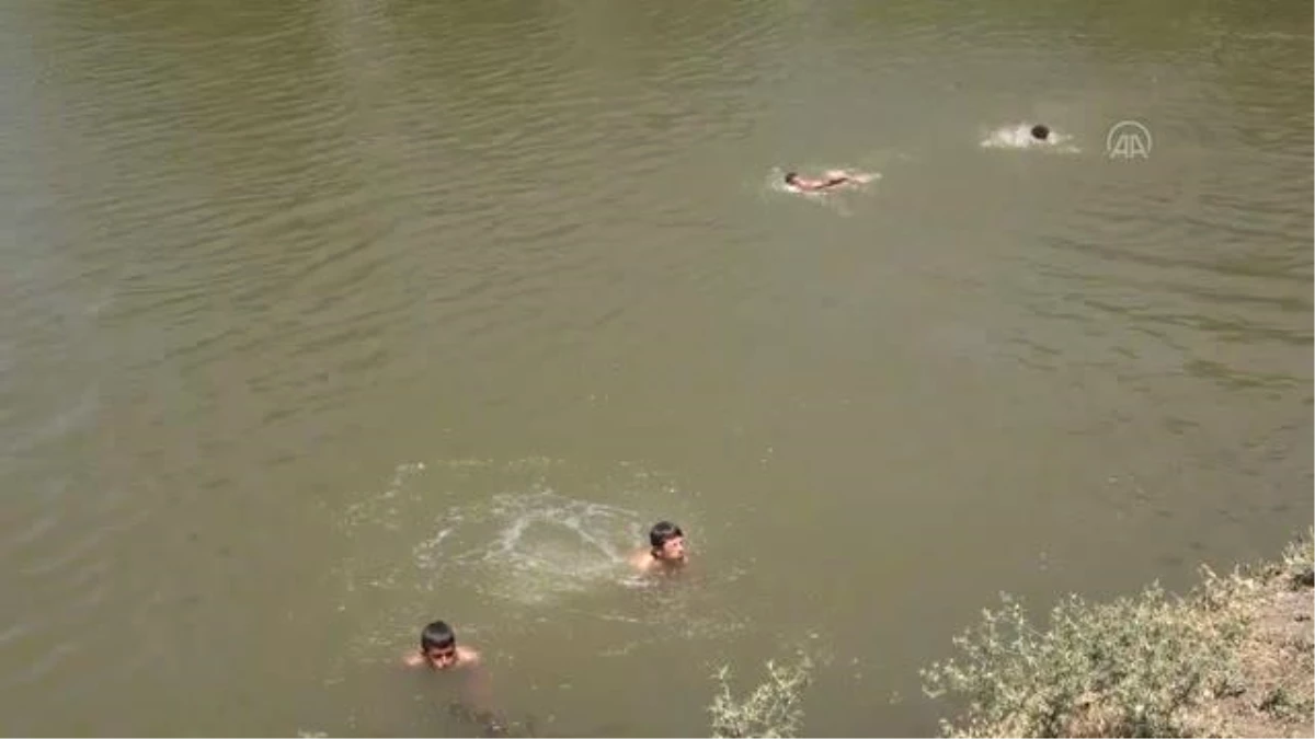 Sıcaktan bunalan çocuklar Karasu Nehri\'nde serinliyor