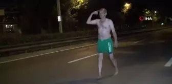 Araçlara aldırış etmeden yolda yarı çıplak yürüdü