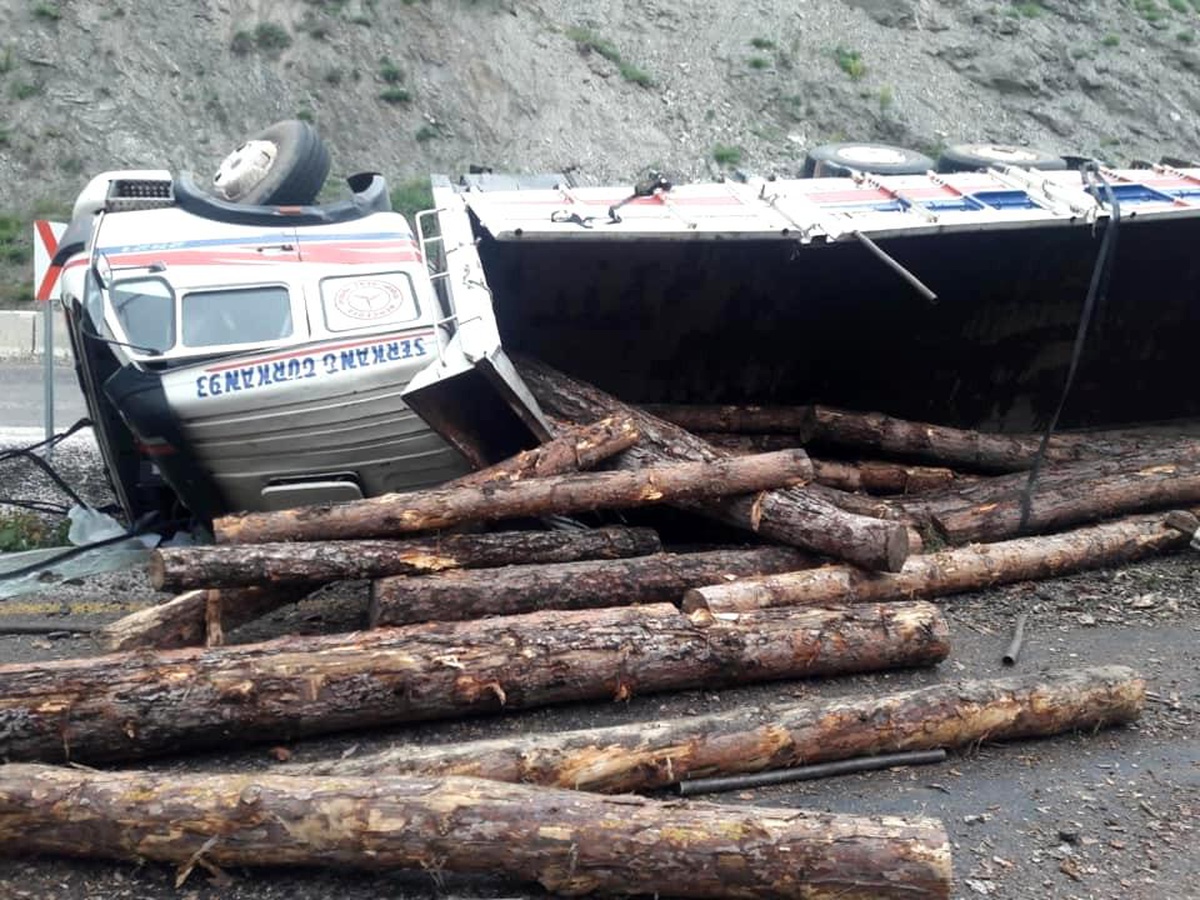 Yan yatan kamyondaki tomruklar otomobilin üstüne devrildi: 2 yaralı