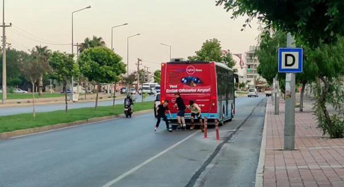 PATENLİ ÇOCUKLAR, TOPRAK ZEMİNDE OTOBÜS ŞOFÖRÜNDEN SEKE SEKE KAÇTI