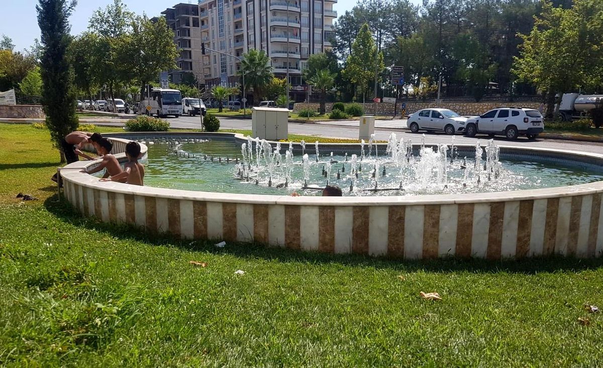 Sıcakta bunalan çocuklar süs havuzunda serinliyor