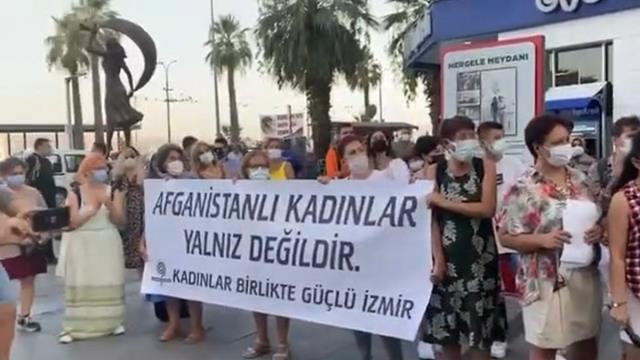 İzmir'de Taliban'ı protesto için toplanan bir grup kadın giydikleri temsili bir çarşafı çıkarıp yerlere attı