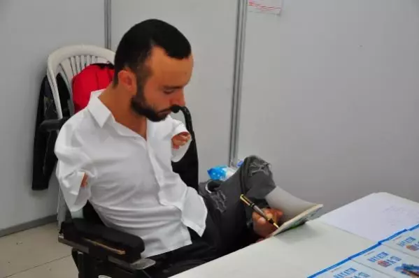 Ayağıyla yazdığı kitabını, okurları için ayağıyla imzaladı