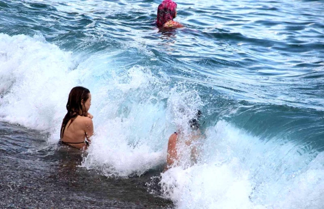 Ekim ayının ortası olmasına rağmen Konyaaltı Sahili'nde tatilciler denize girdi