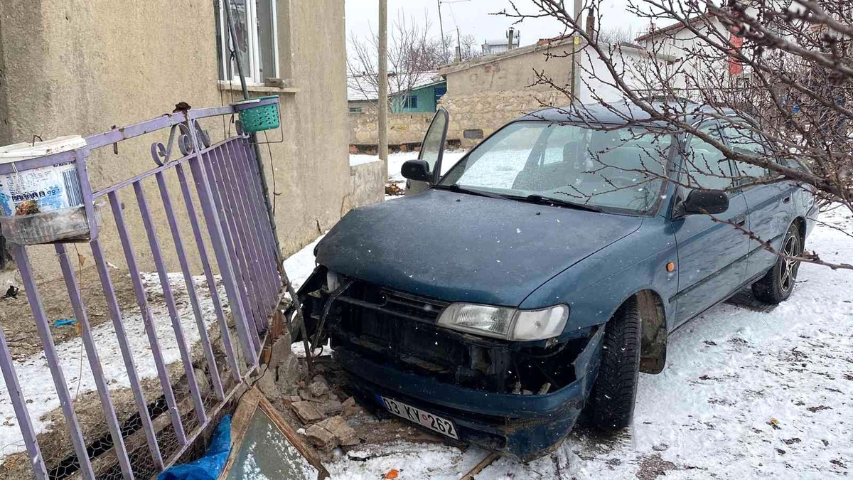 Karlı yolda kayan otomobil evin balkonuna çarparak durabildi