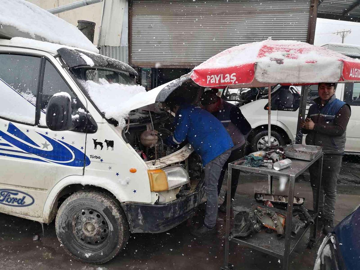 Plaj şemsiyesi altında araç tamiri