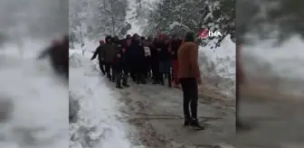 Kardan kapanan yolu açmaya çalışan iş makinesi devrildi: 2 yaralı