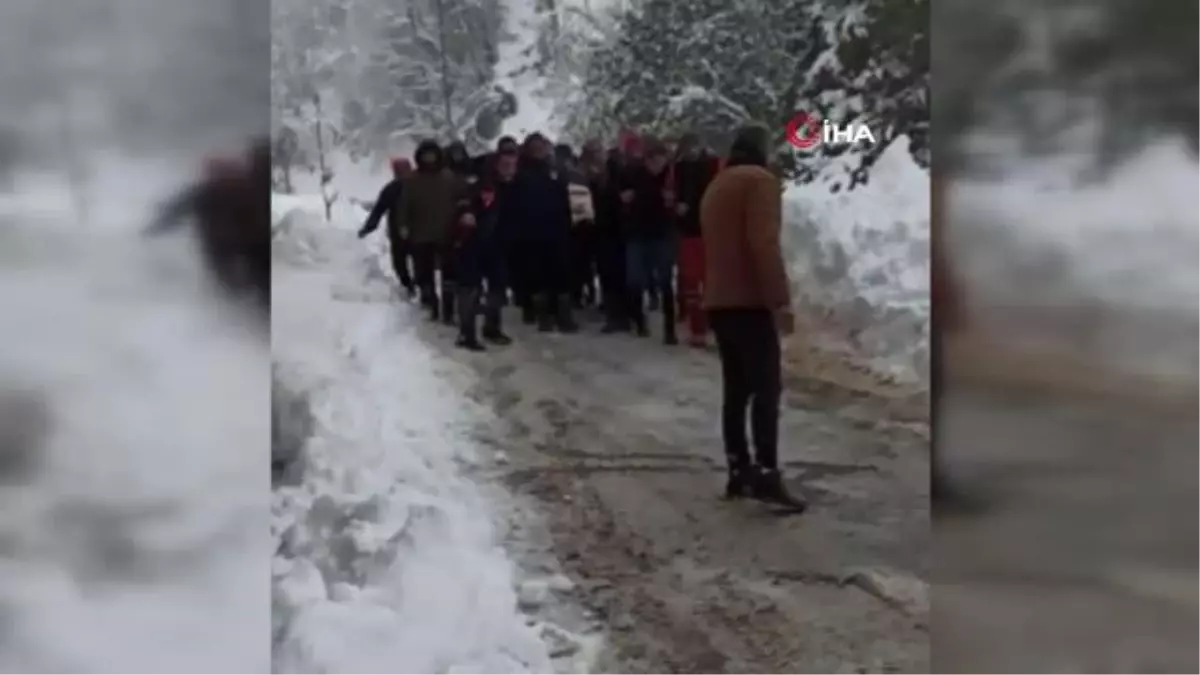 Kardan kapanan yolu açmaya çalışan iş makinesi devrildi: 2 yaralı