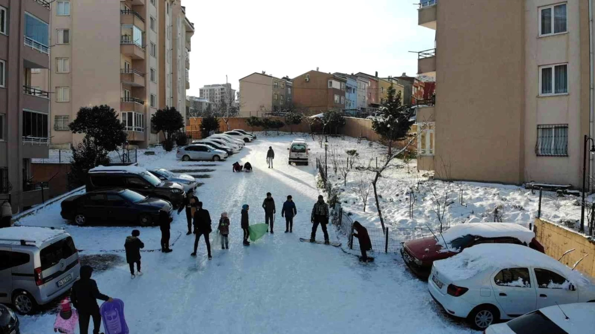 Pendik\'te kayaksever bahçede snowboard yaptı, çocuklar poşetle eşlik etti