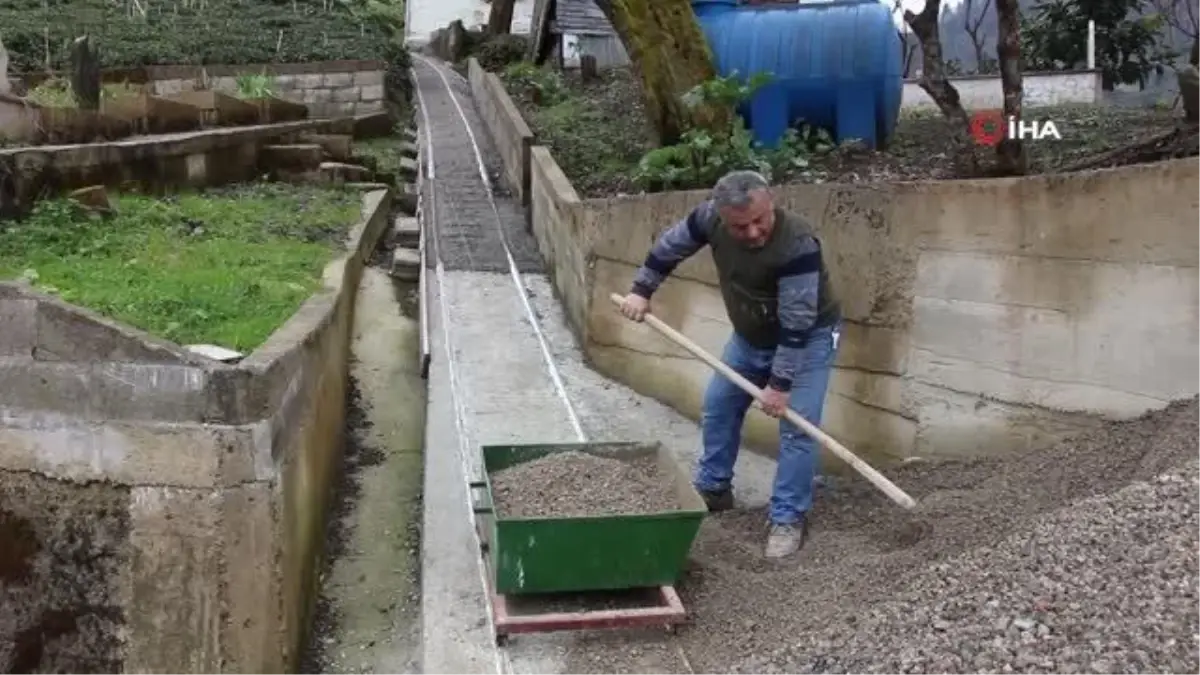 Ev yapacağı alana giden patika yola ray döşeyen Hacıefendioğlu, inşaat malzemelerini yaptığı düzenekle taşıyor