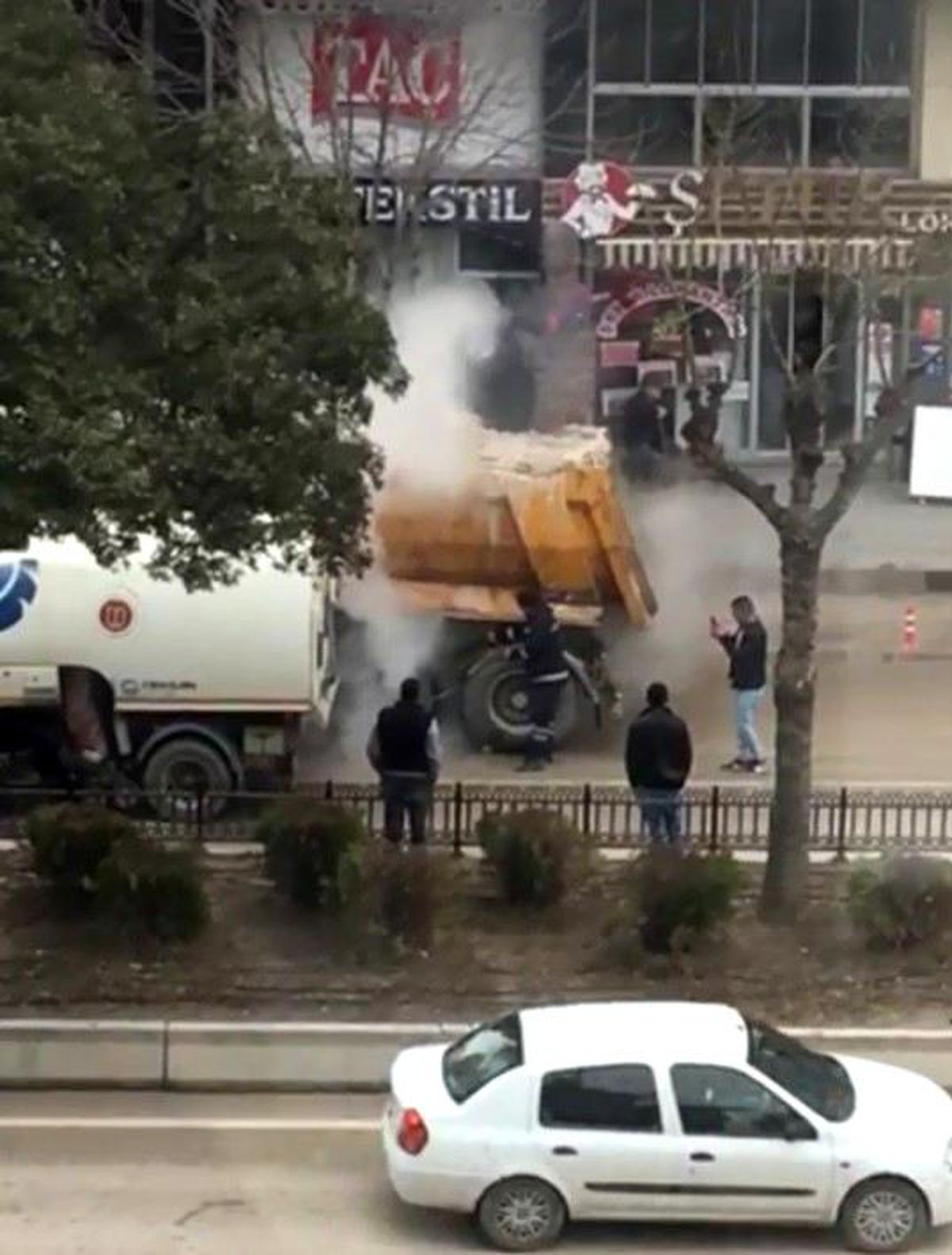 Bilecik\'te aracının lastiği tutuşan sürücü alevleri söndürmek için büfeden su taşıdı