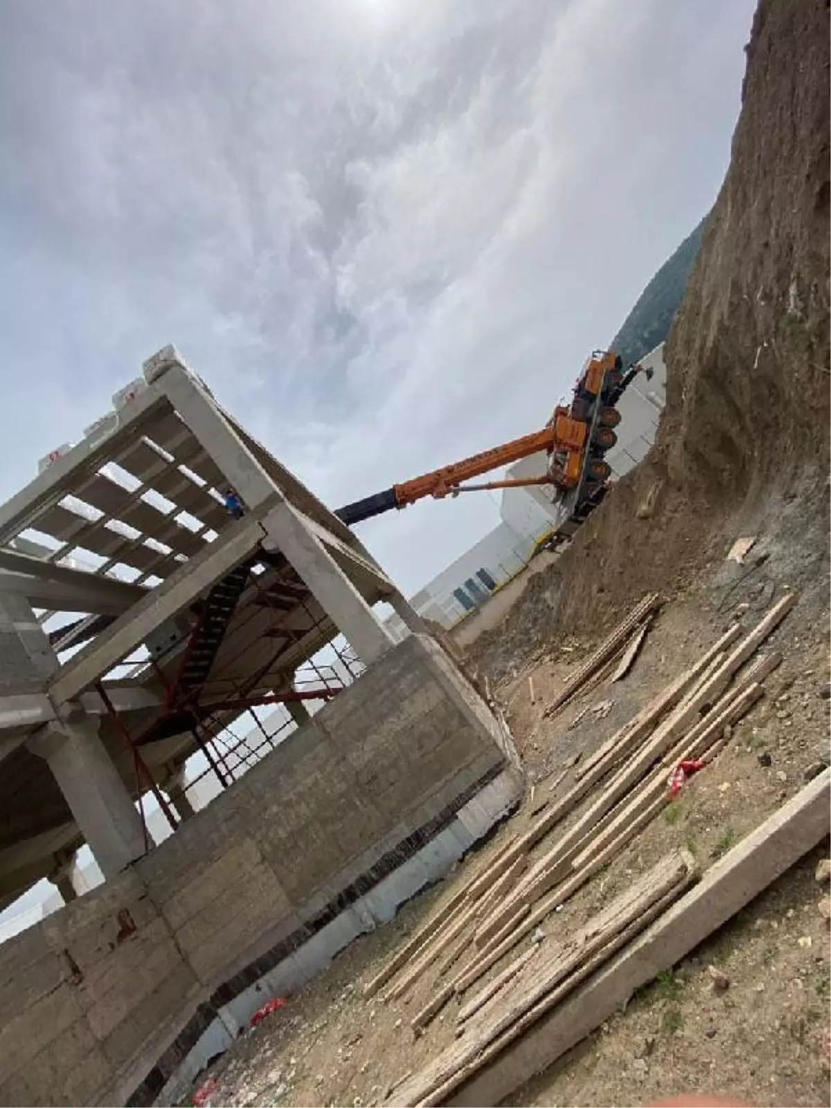 İnşaata malzeme çıkarılan vinç, ağırlığı taşıyamayınca devrildi