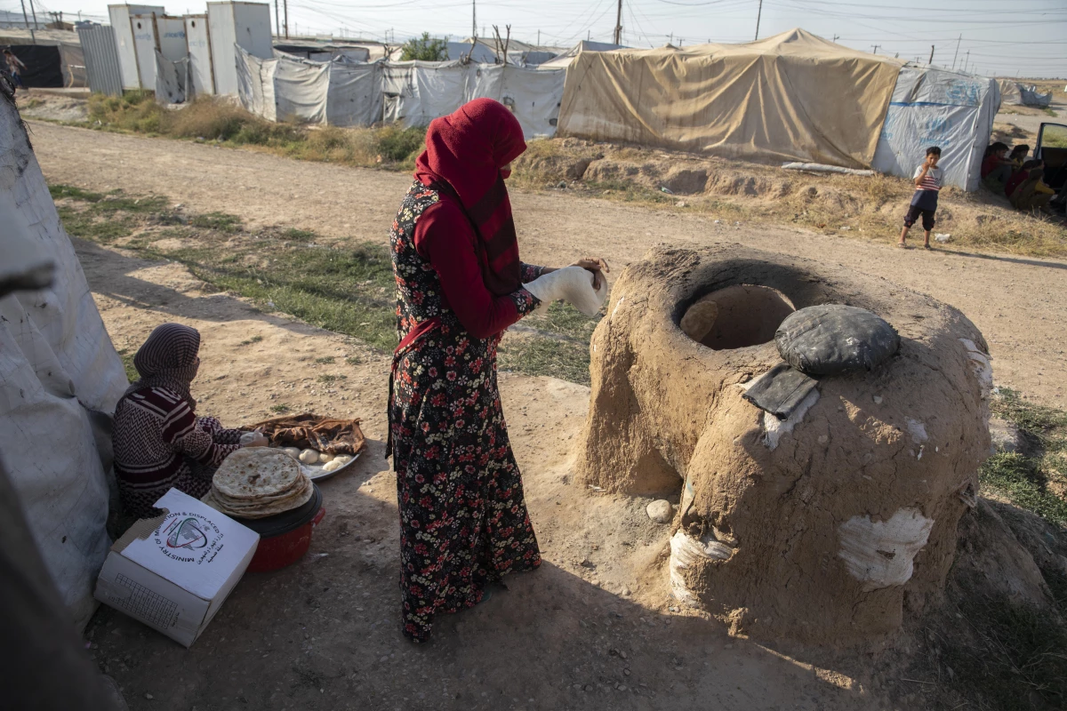 DEAŞ\'tan kaçarak Musul\'daki mülteci kampına sığınan kadınlar ekmeklerini 6 yıldır tandırda pişiriyor