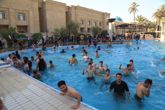 Irak'ta Sadr destekçileri hükümet sarayını basarak yüzme havuzunda serinlediler Irak'ta Sadr destekçileri hükümet sarayını basarak yüzme havuzunda serinlediler