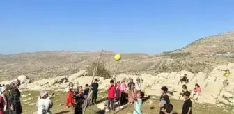 Siirtli çocuklar ip ve odun parçasından voleybol sahası yapıp gönüllerince eğlendi