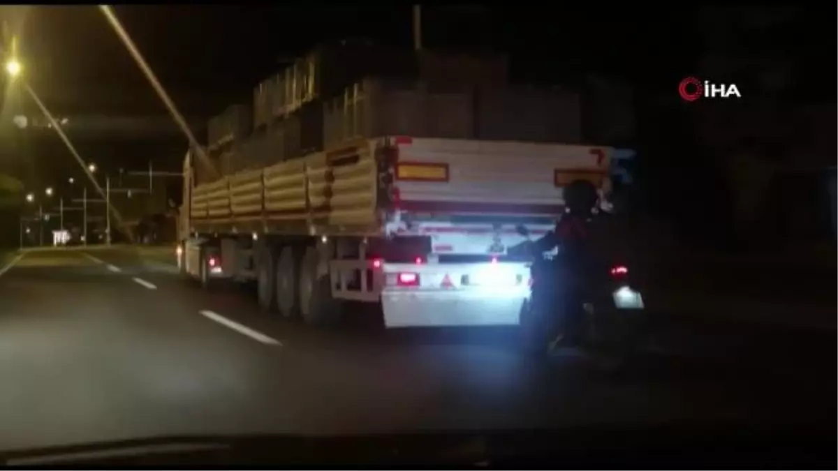 Kamyonun arkasına takılarak giden motosiklet sürücüsü yürekleri ağza getirdi