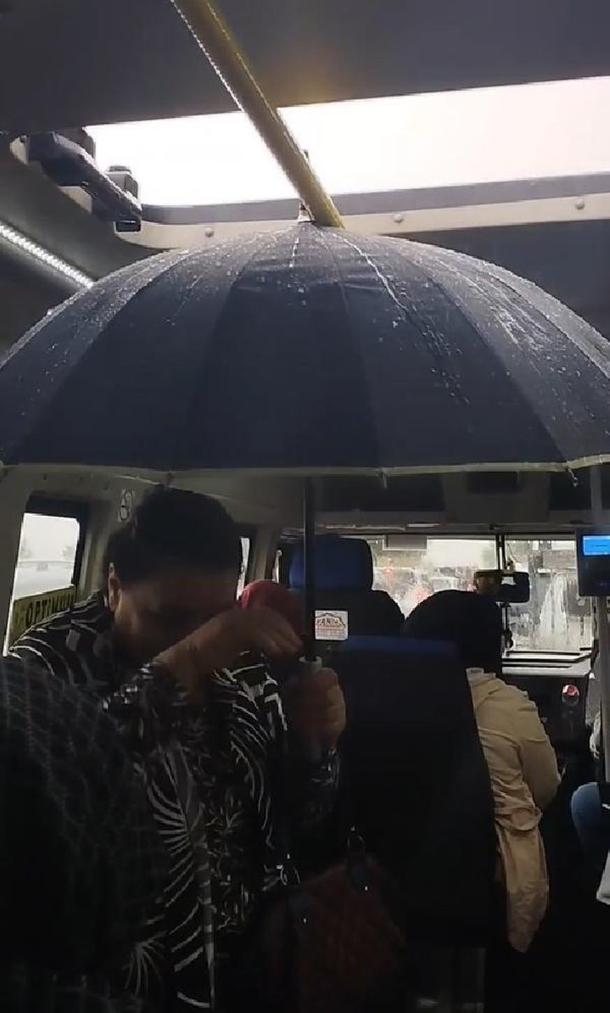 Dolmuşta şemsiyeyle yağmurdan korundu