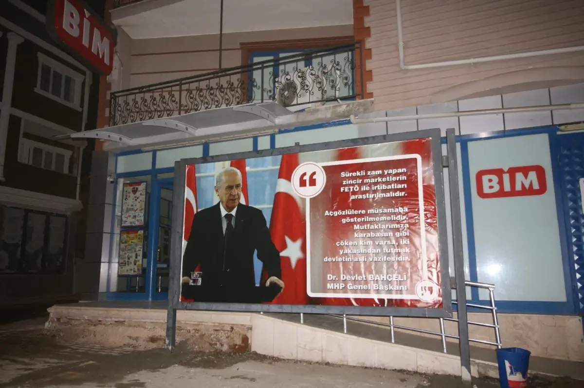 MHP\'li Tefenni Belediyesi, İlçedeki Zincir Market Şubesinin Önüne, Üzerinde Devlet Bahçeli\'nin Sözlerine Yer Verilen Reklam Panosu Yerleştirdi